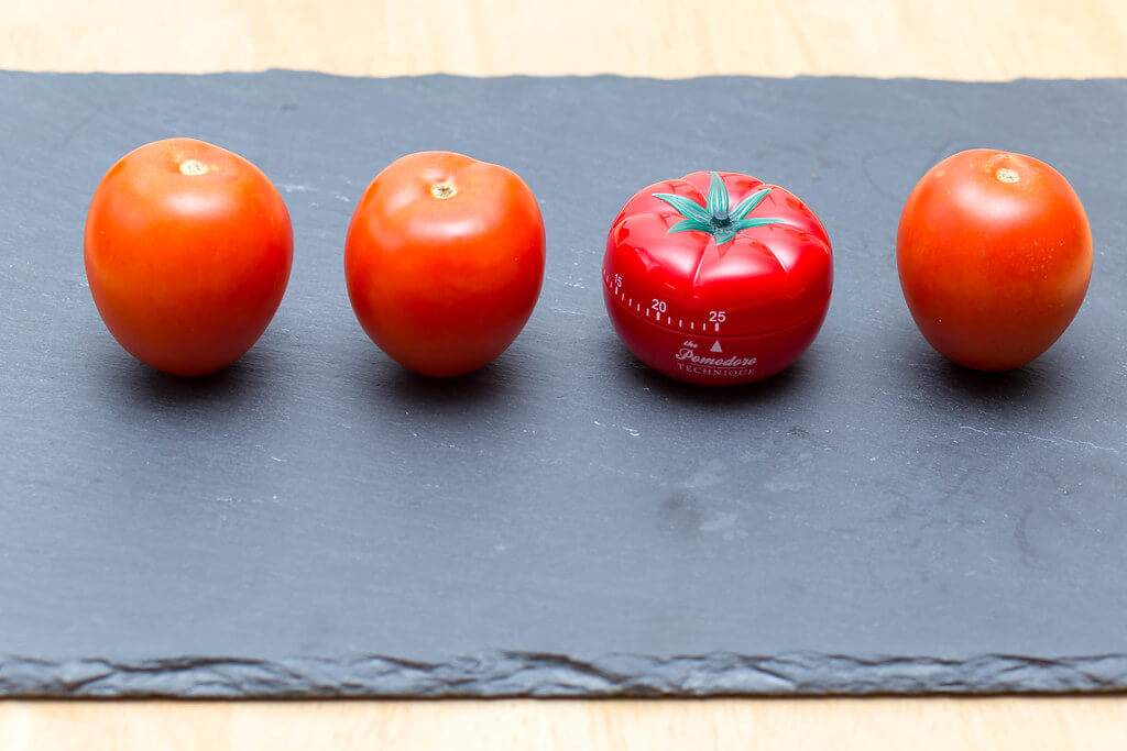 Pass the tomatoes sitting on a slate cutting board for the red Pomodoro timer to help you set time management goals
