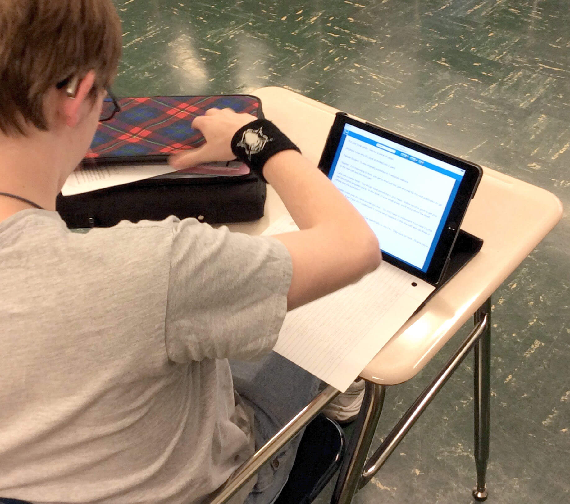 student sitting at his desk reading a TypeWell transcript on his Indispensable iPad
